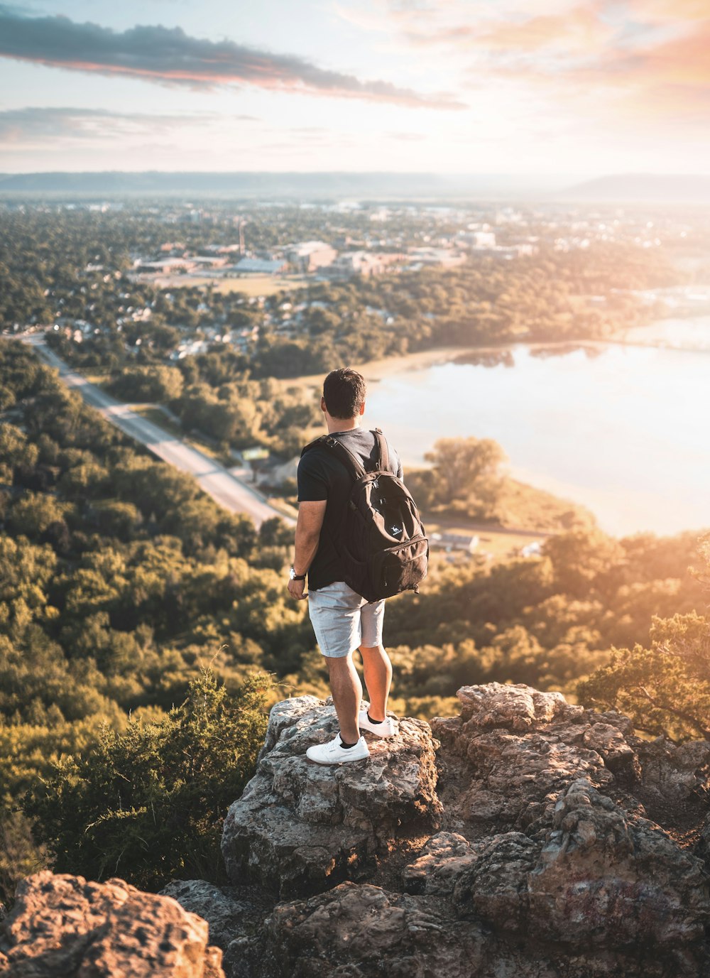 man in black t-shirt standing on rock during daytime