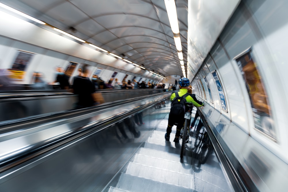 Personas caminando por las escaleras mecánicas dentro del edificio