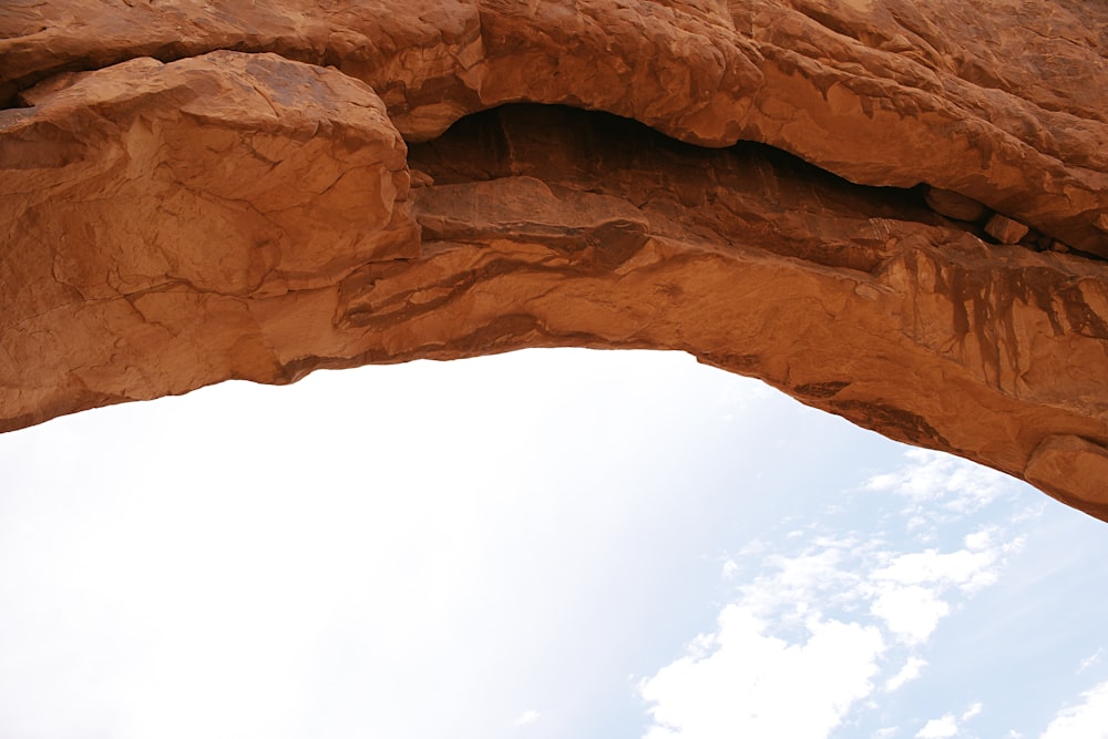 brown rock formation under white clouds during daytime