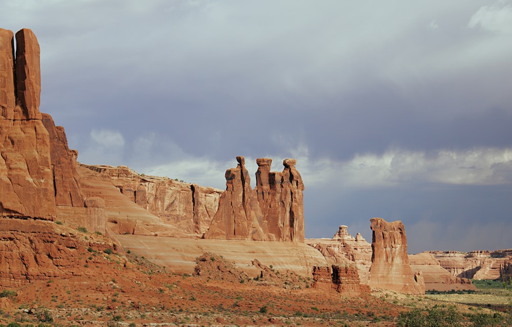 brown rock formation under white clouds during daytime