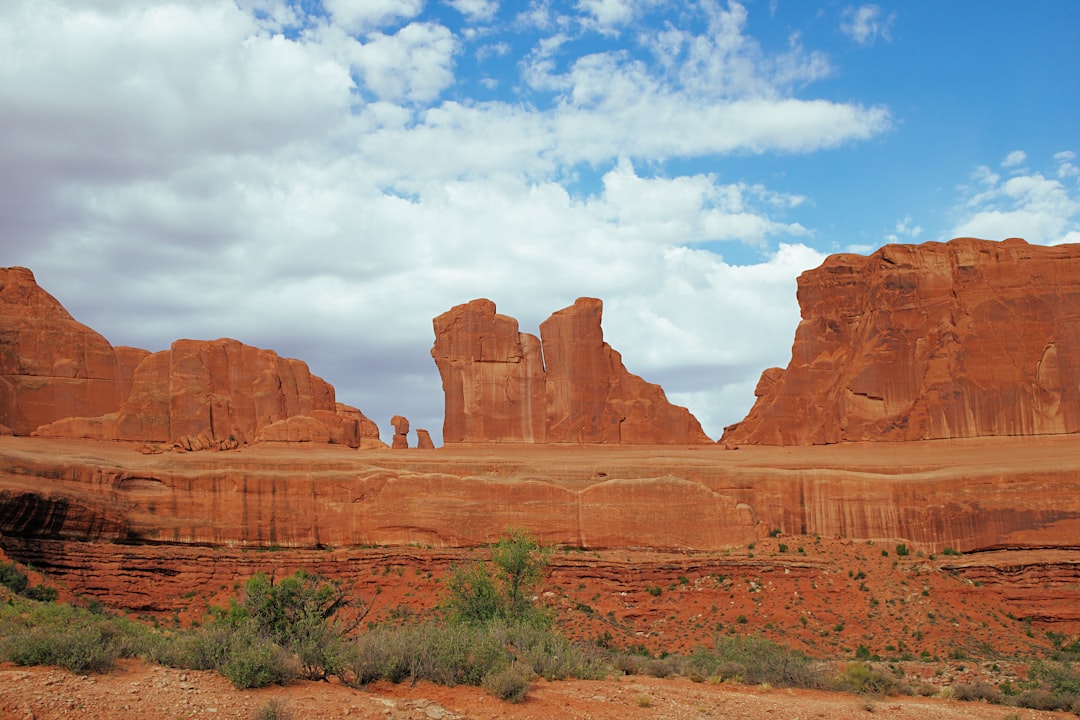 brown rock formation under white clouds and blue sky during daytime