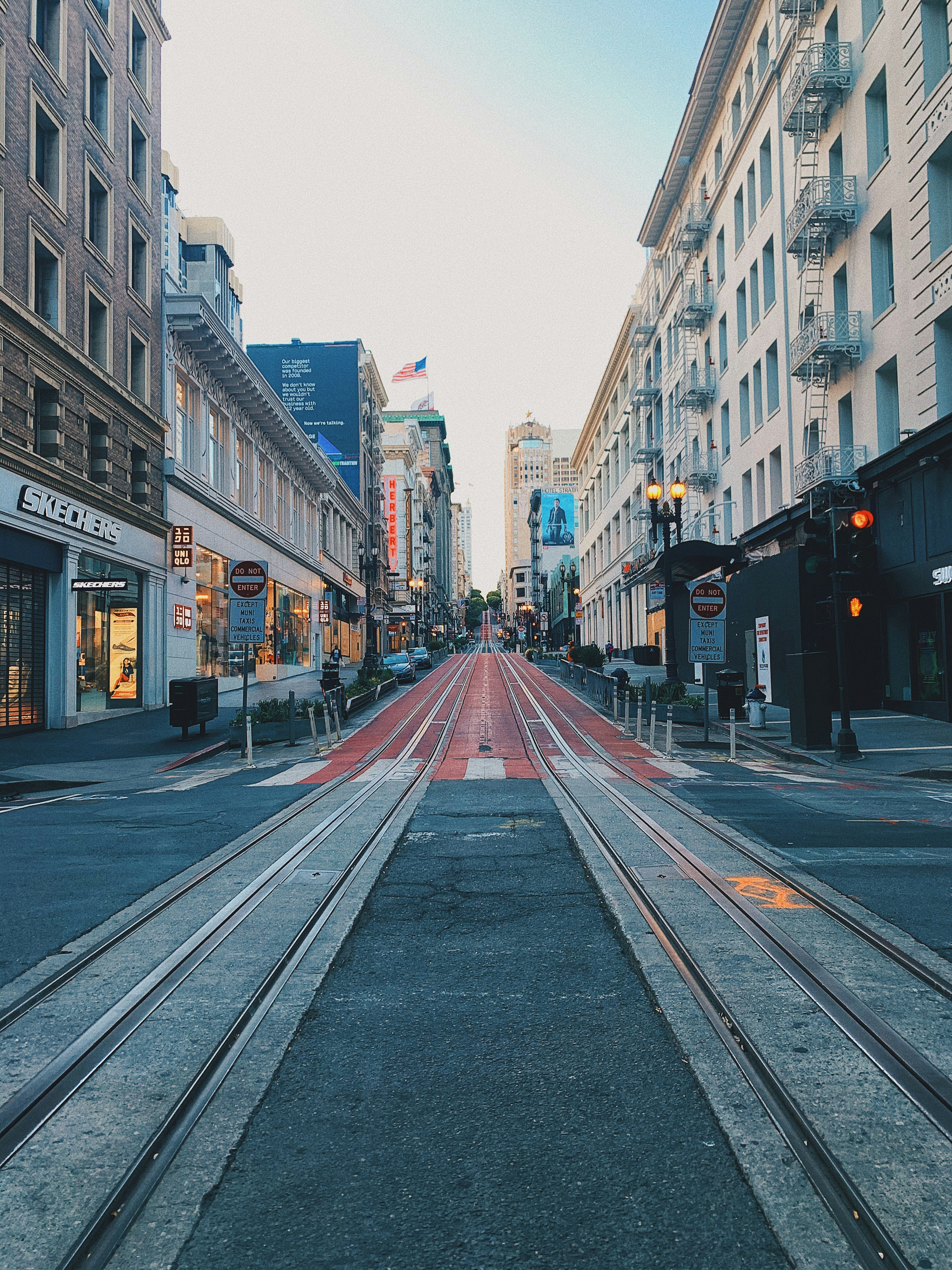 gray concrete road between high rise buildings during daytime