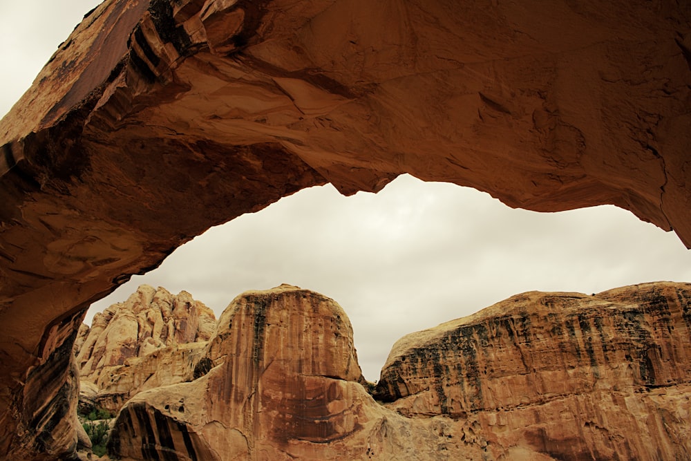 brown rock formation under white clouds during daytime