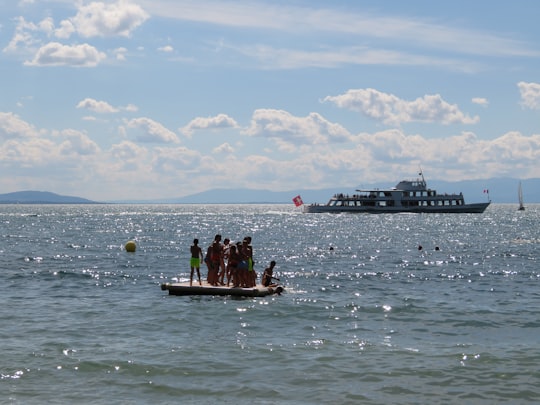 people riding on brown boat on sea during daytime in Lutry Switzerland