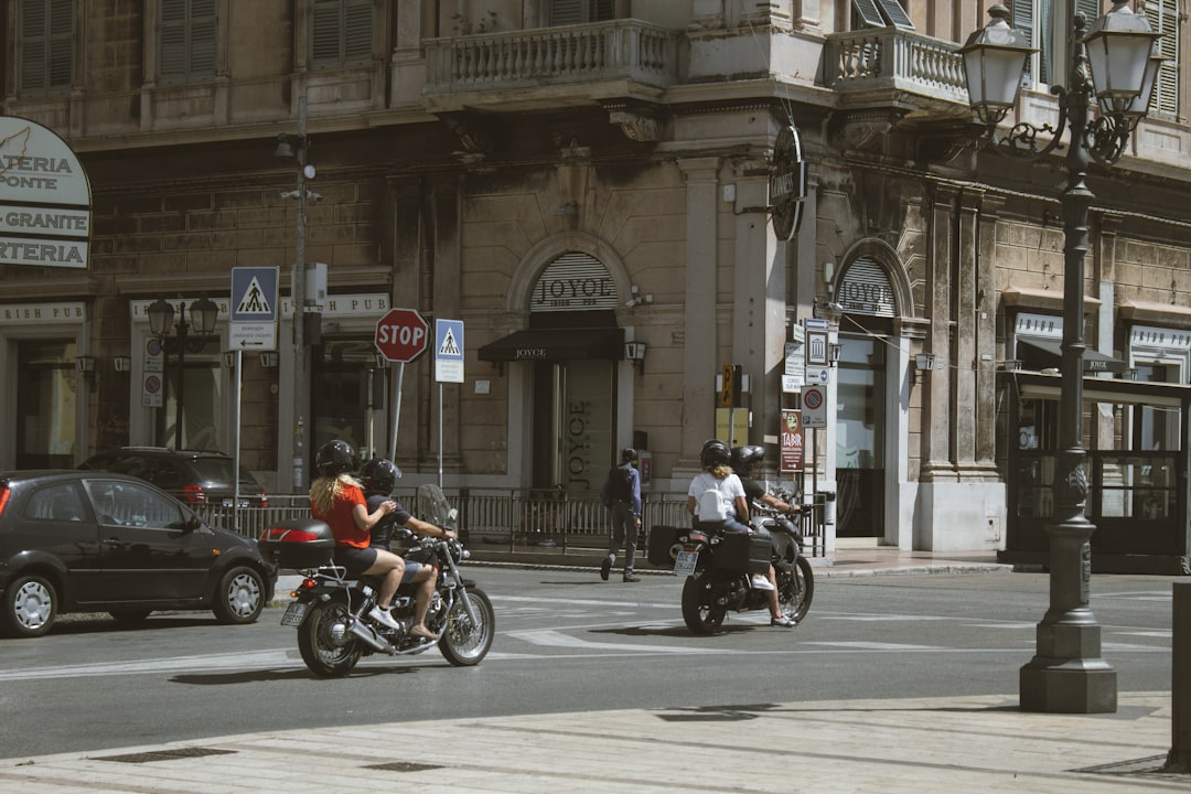 people riding motorcycle on road near building during daytime