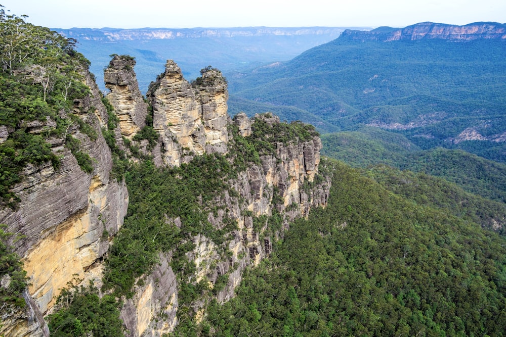 montaña verde y marrón bajo el cielo blanco durante el día