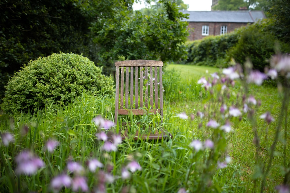 chaise en bois marron sur le champ d’herbe verte pendant la journée