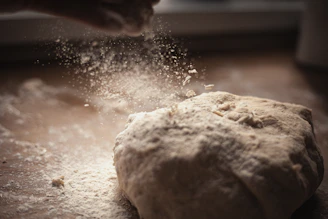 Close-up of natural stone-ground flour spilling gently onto a wooden surface.