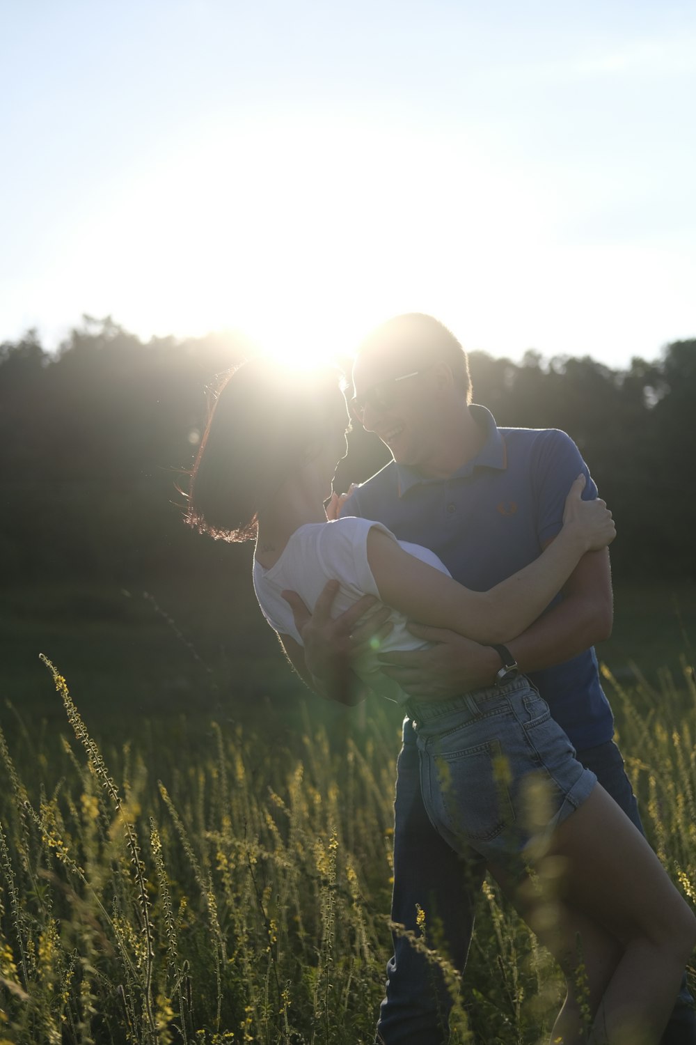 man in black t-shirt carrying woman in white t-shirt during daytime