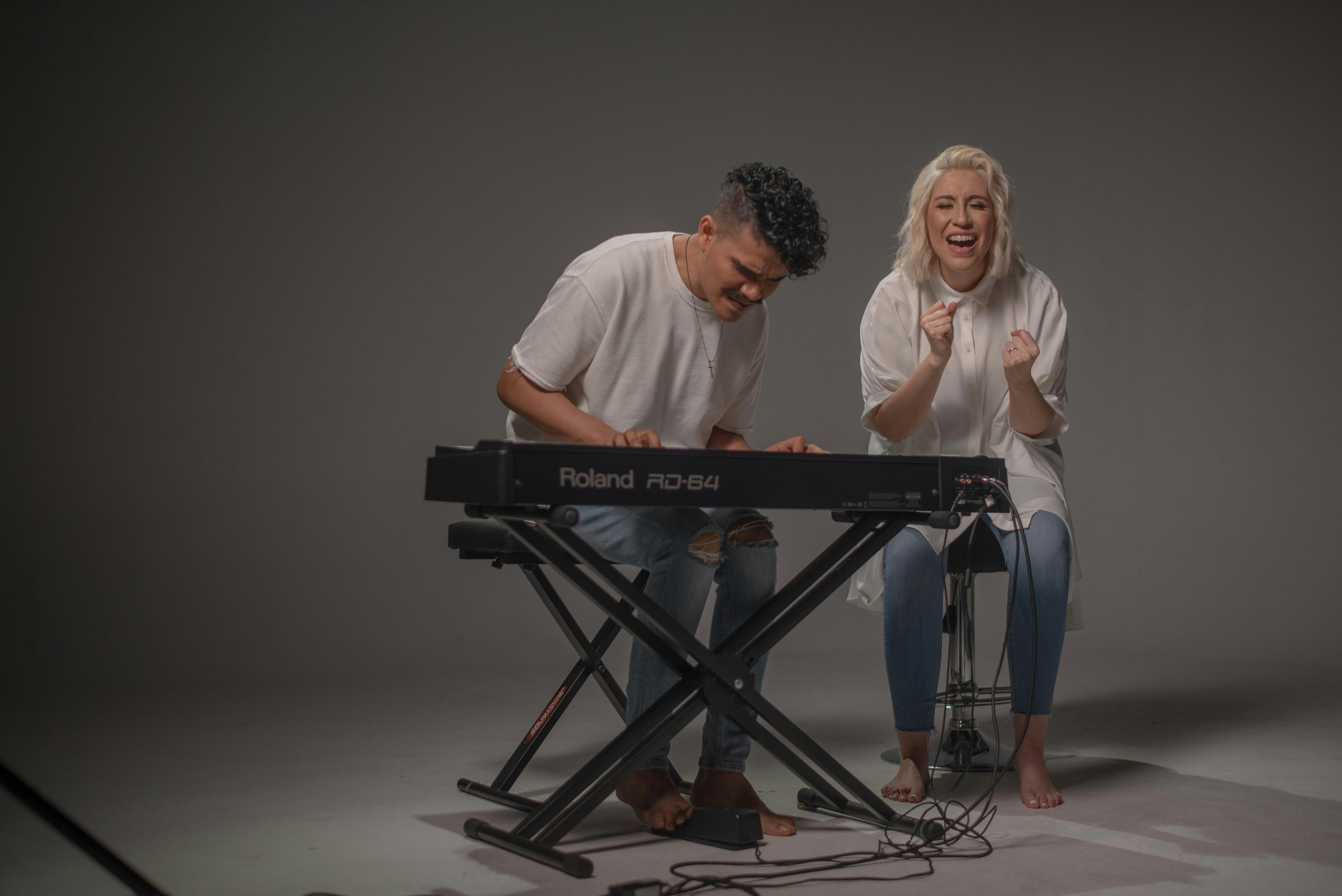 Mann im weißen Rundhals-T-Shirt sitzt neben Frau im weißen Rundhals-T-Shirt