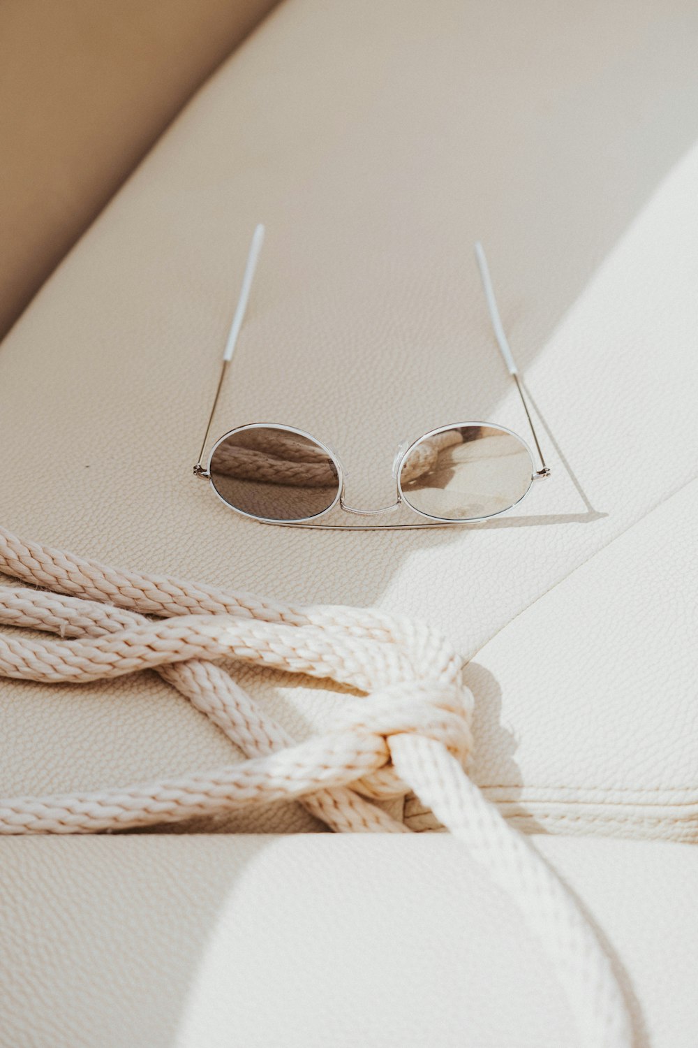 silver framed aviator style sunglasses on white textile