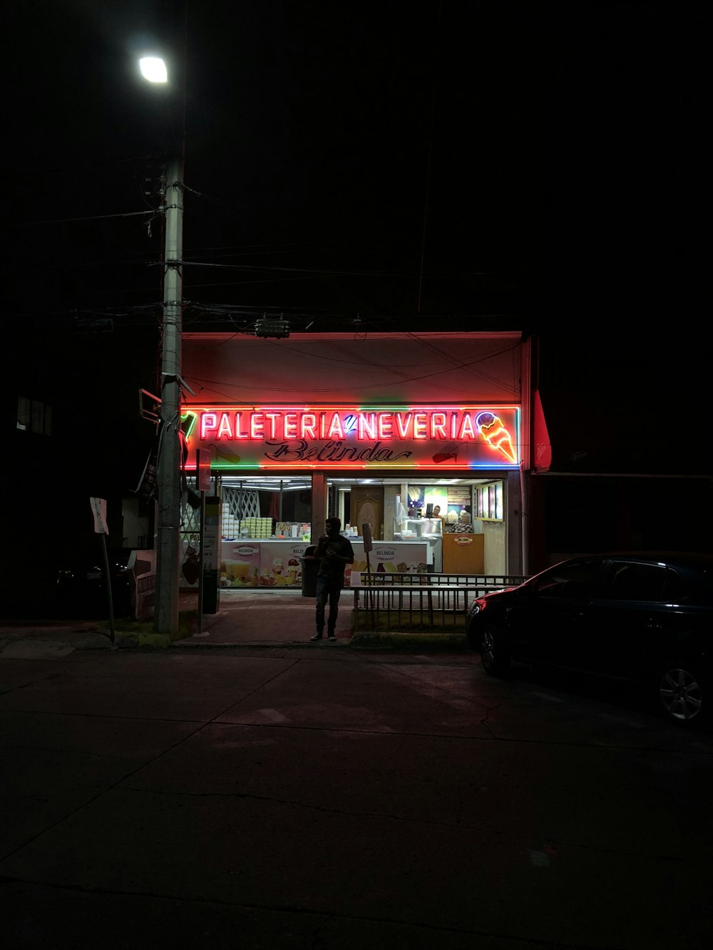 black car parked near store during night time