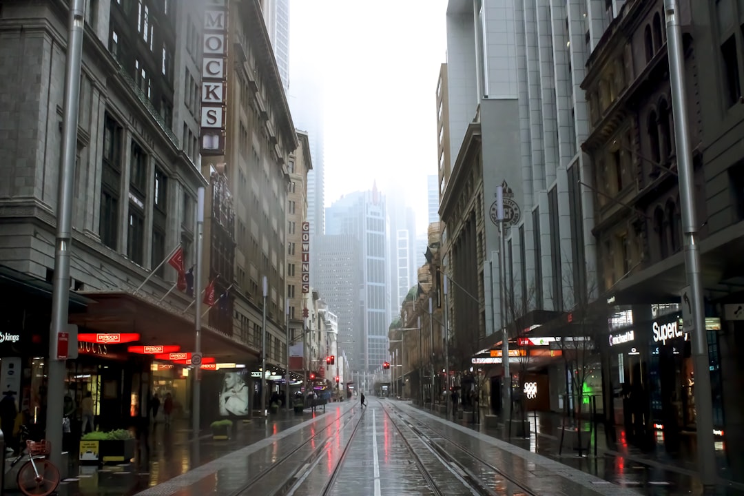 cars on road between high rise buildings during daytime