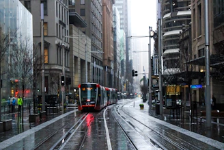 red and black tram on road between buildings during daytime