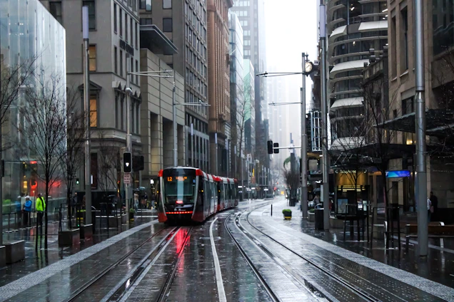 red and black tram on road between buildings during daytime