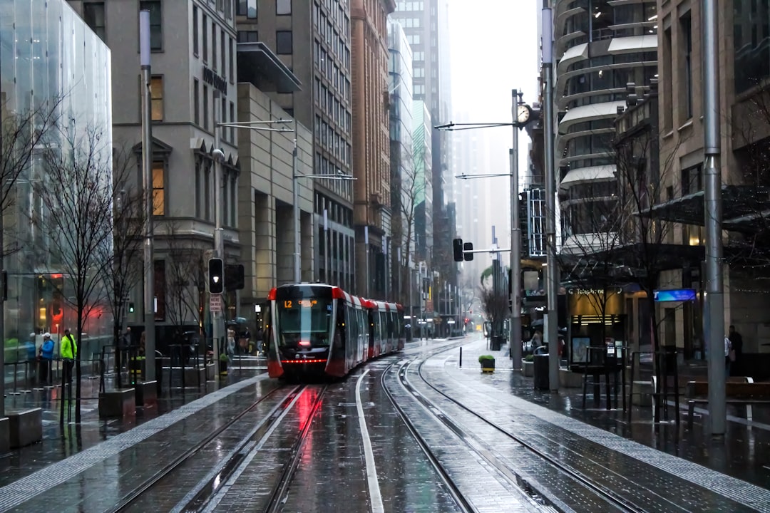 red and black tram on road between buildings during daytime