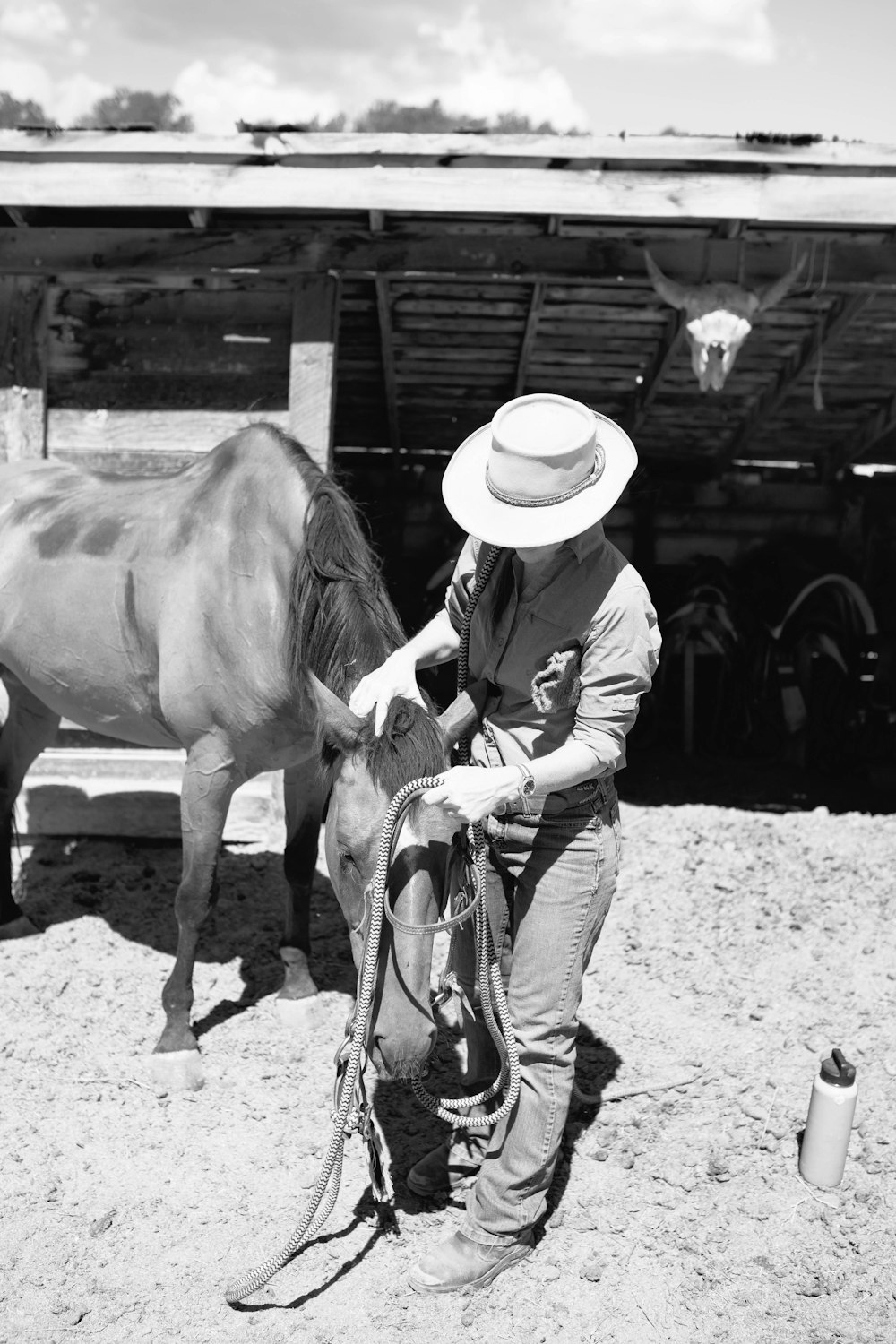 grayscale photo of woman in cowboy hat riding horse