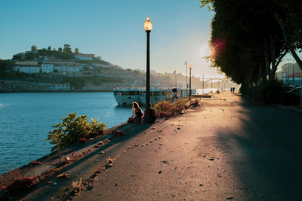 people walking on sidewalk near body of water during daytime