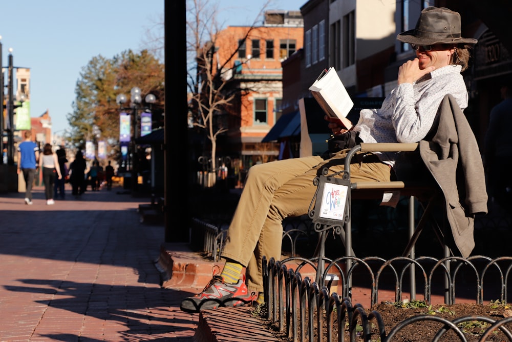 man in white dress shirt sitting on black steel bench during daytime