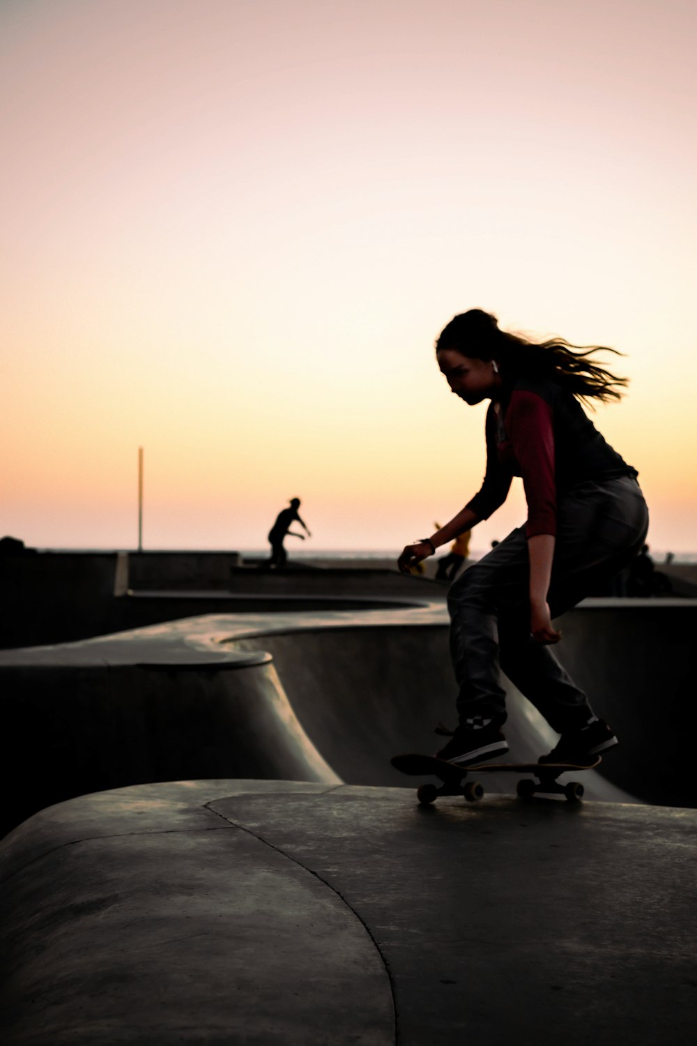 woman in black jacket and pants jumping on gray concrete surface during daytime