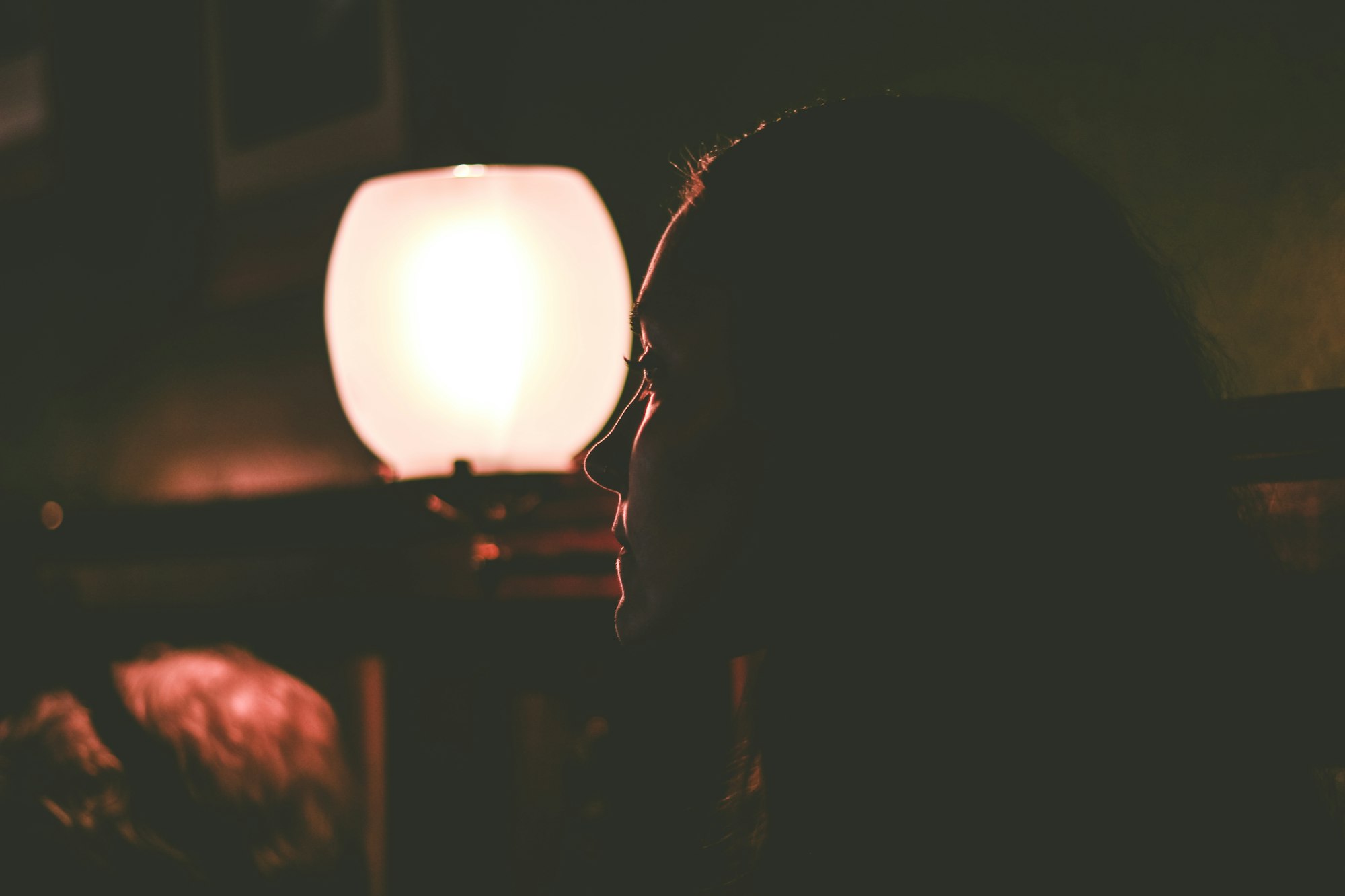 A woman lit by a red lamp 