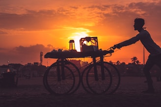 silhouette of bicycle on beach during sunset