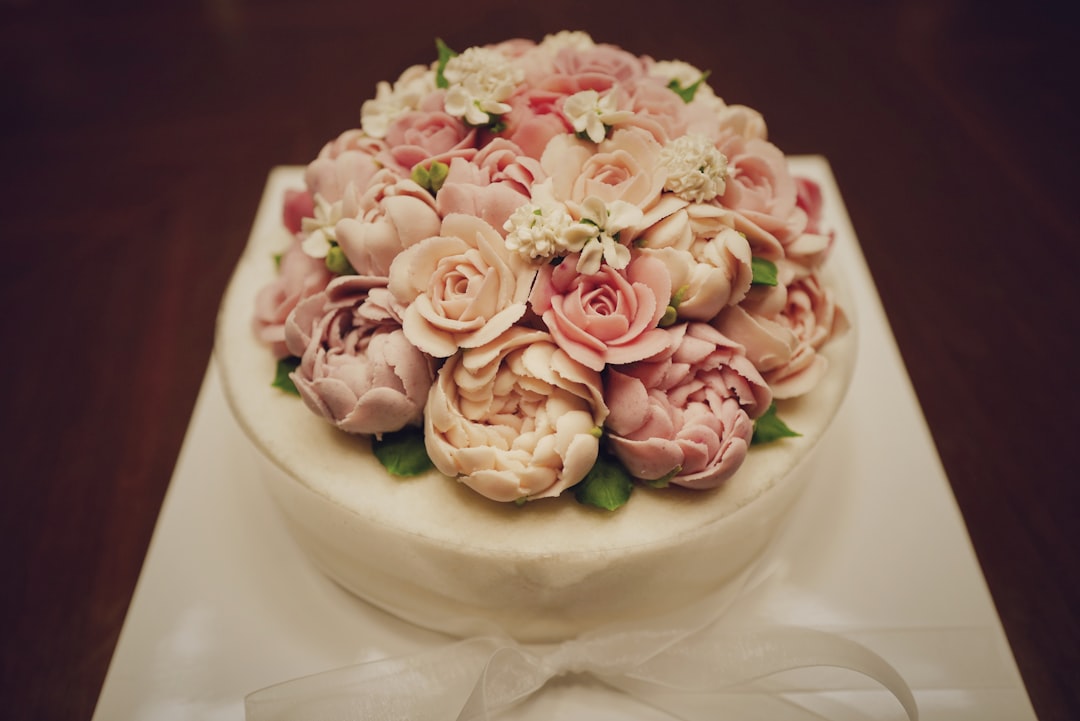 pink and white roses on white round cake