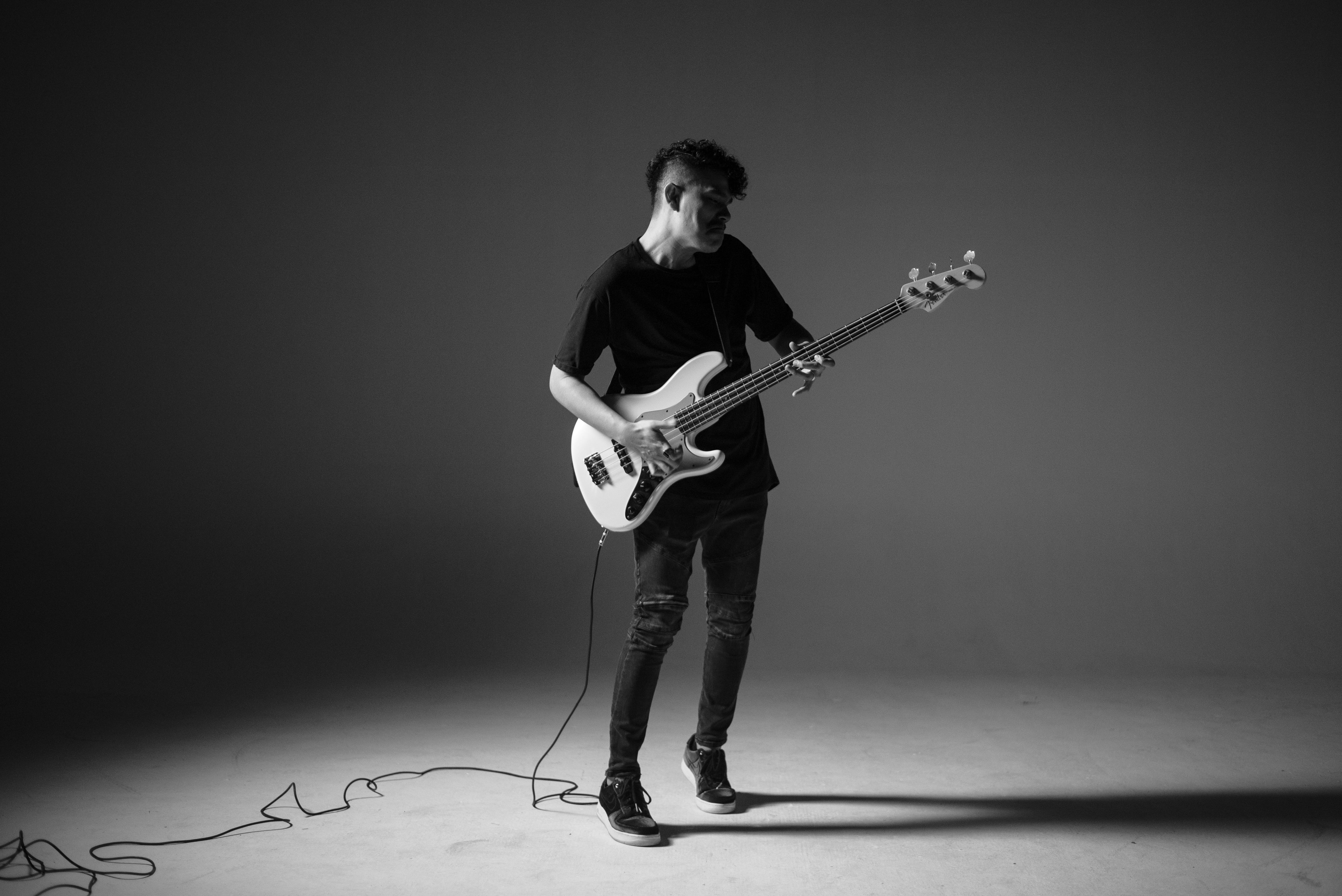 man playing guitar in grayscale photography