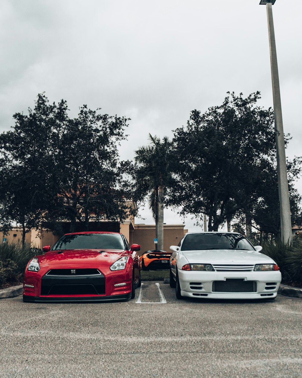 red and white cars parked on the side of the road during daytime