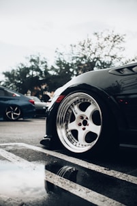 black car with white wheel on the road
