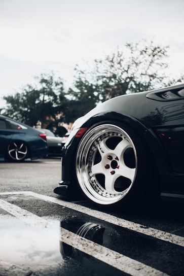 black car with white wheel on the road