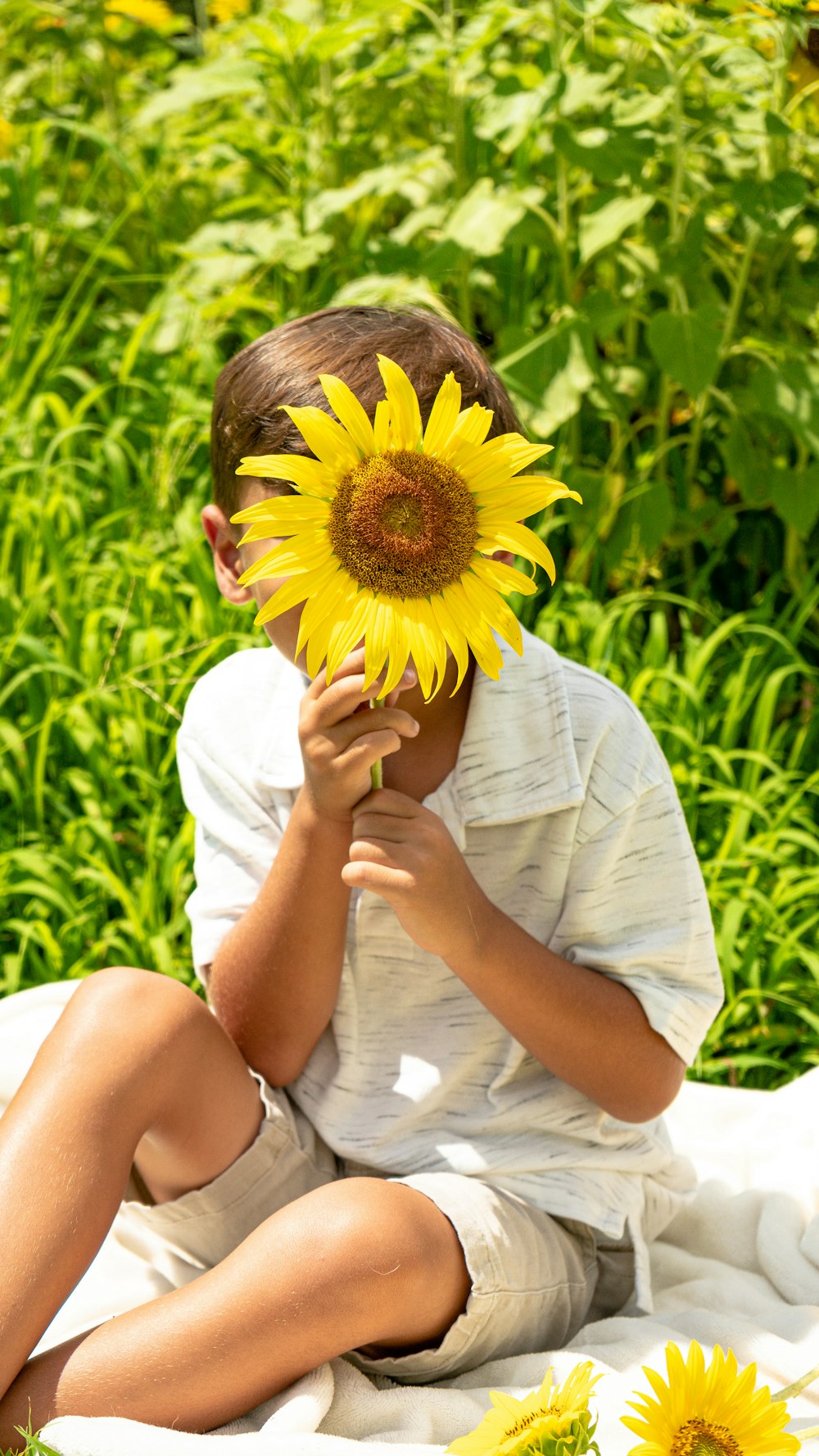 man in white t-shirt holding sunflower