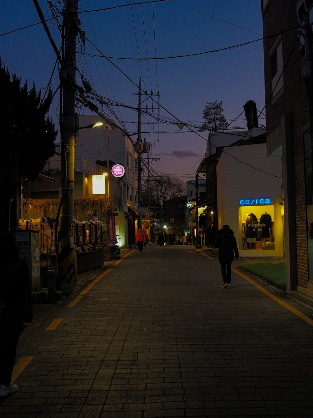 people walking on sidewalk during night time