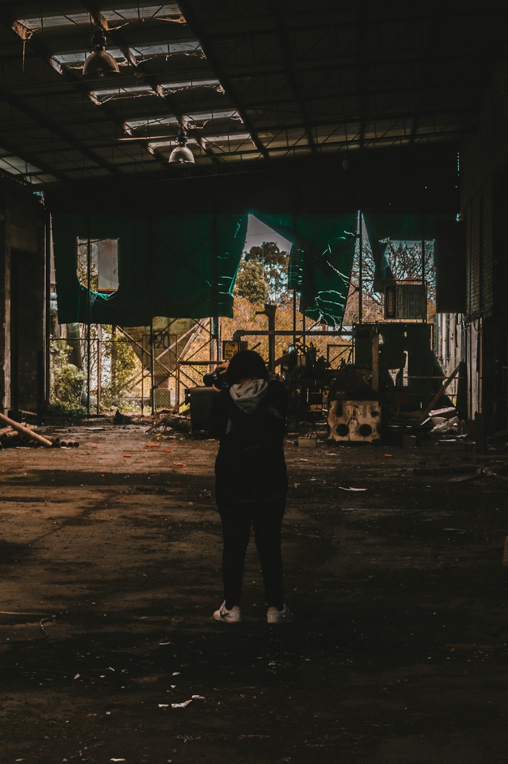 man in black jacket standing near brown wooden house during night time