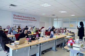 A vibrant classroom setting with students engaged in an ISO certification course on their laptops.