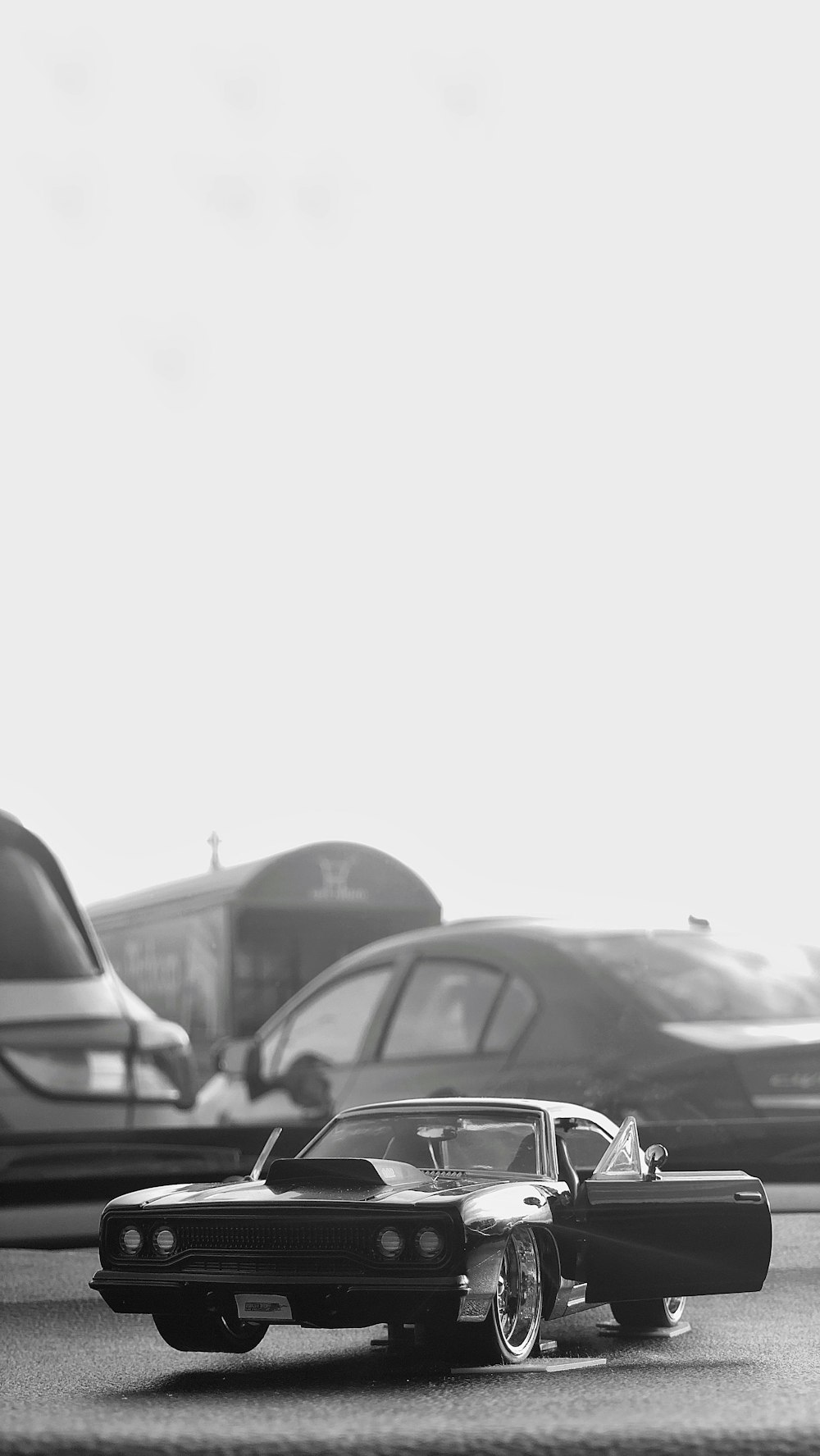 grayscale photo of cars parked on parking lot