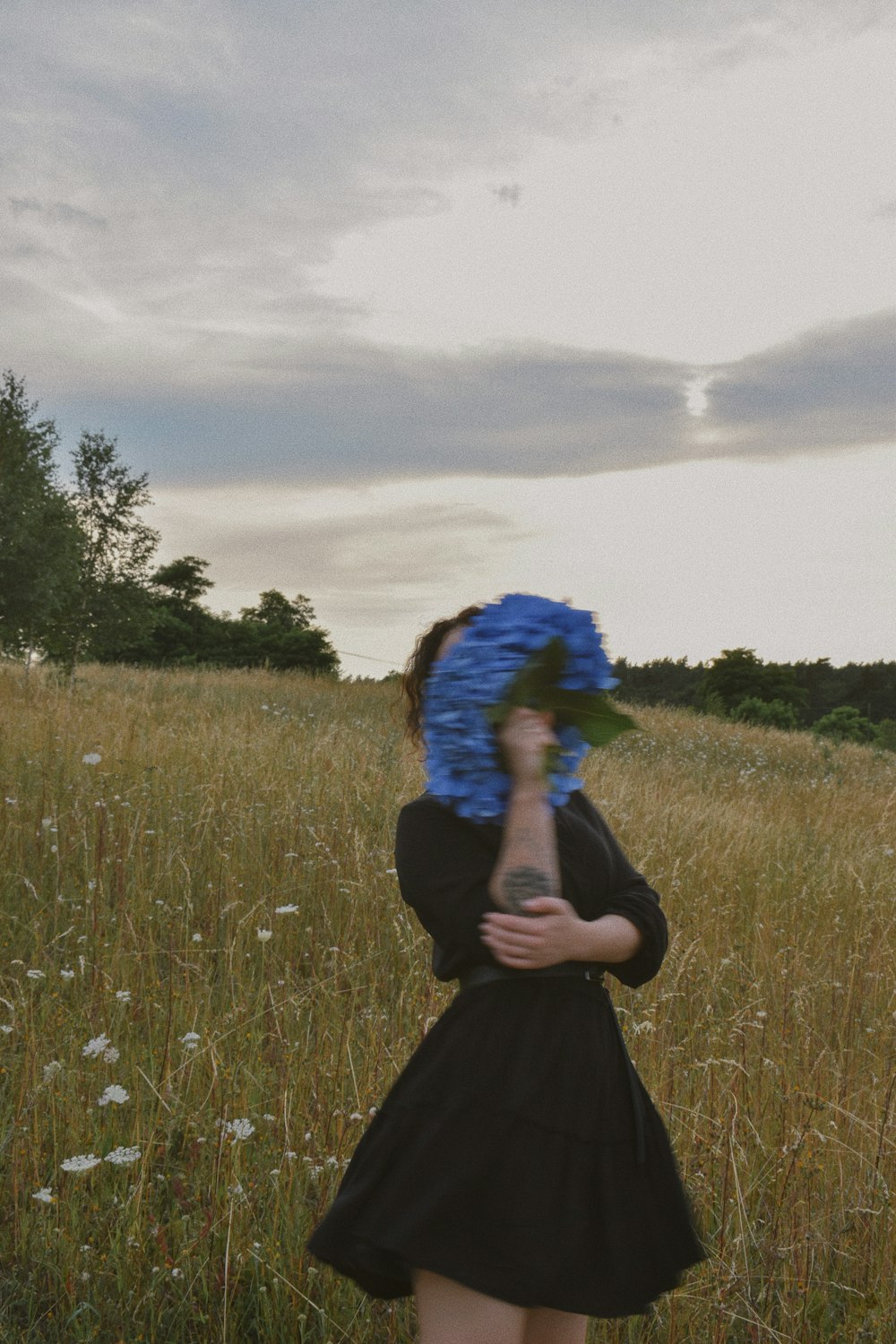 woman in black long sleeve dress standing on green grass field during daytime