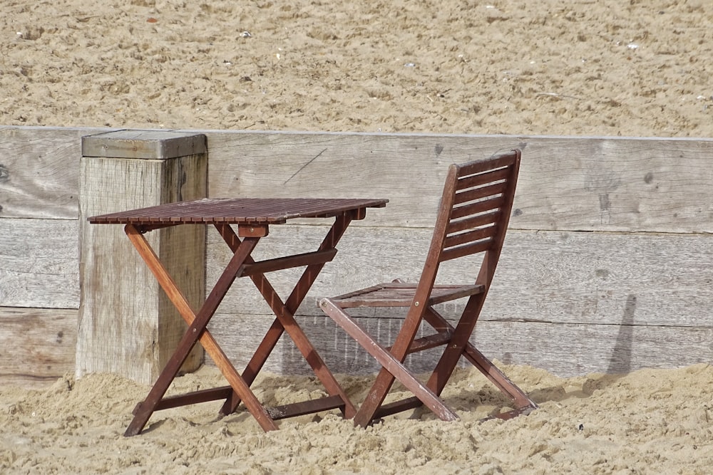 mesa dobrável de madeira marrom na areia marrom durante o dia