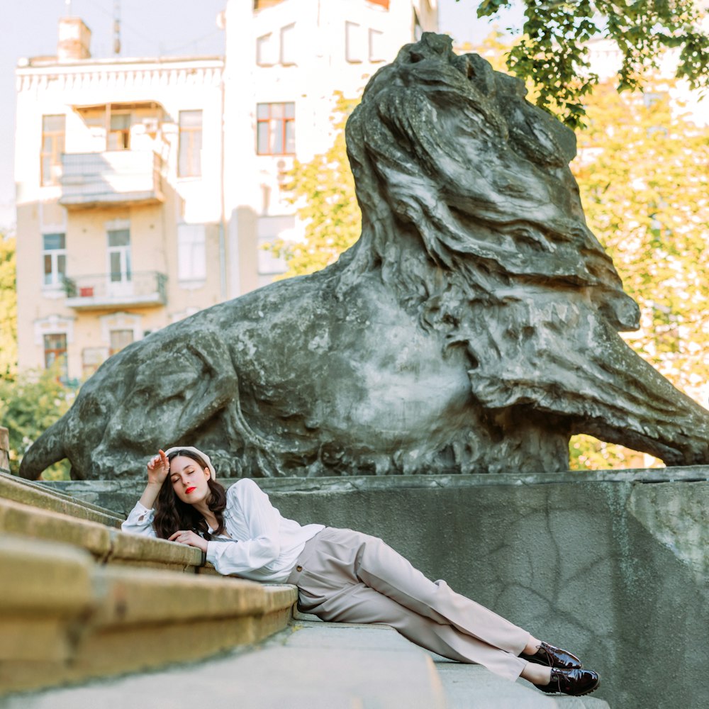 woman in white long sleeve shirt and white pants sitting on concrete bench