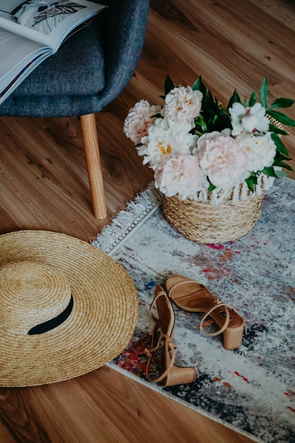 brown straw hat beside white flowers on brown wooden table