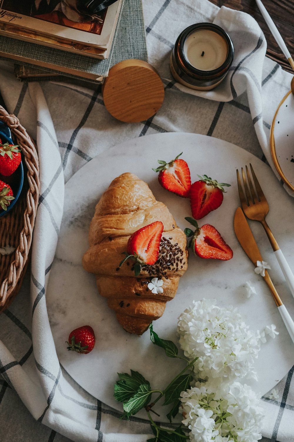 bread with sliced strawberries and green leaves on white ceramic plate