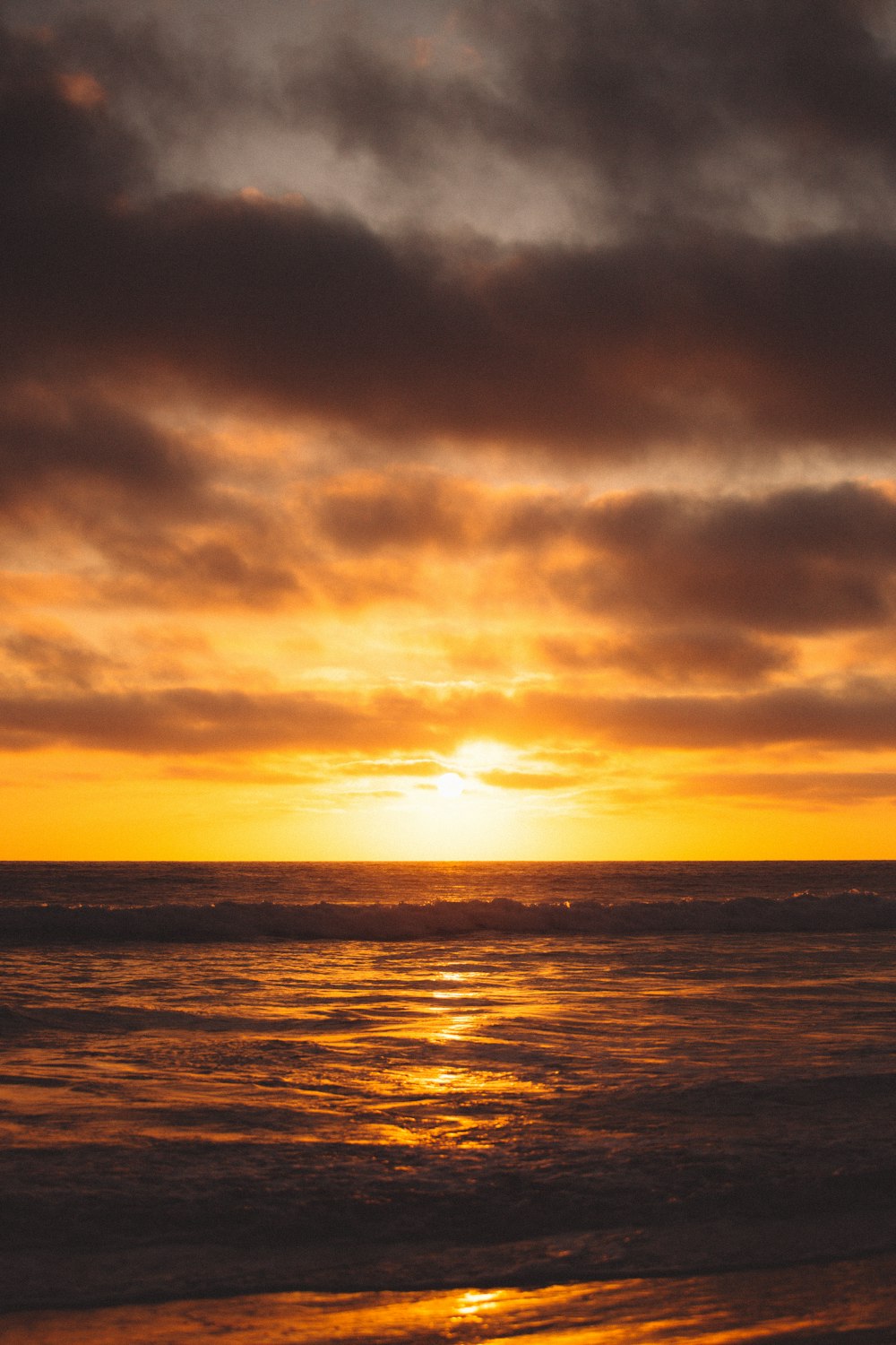 body of water under cloudy sky during sunset