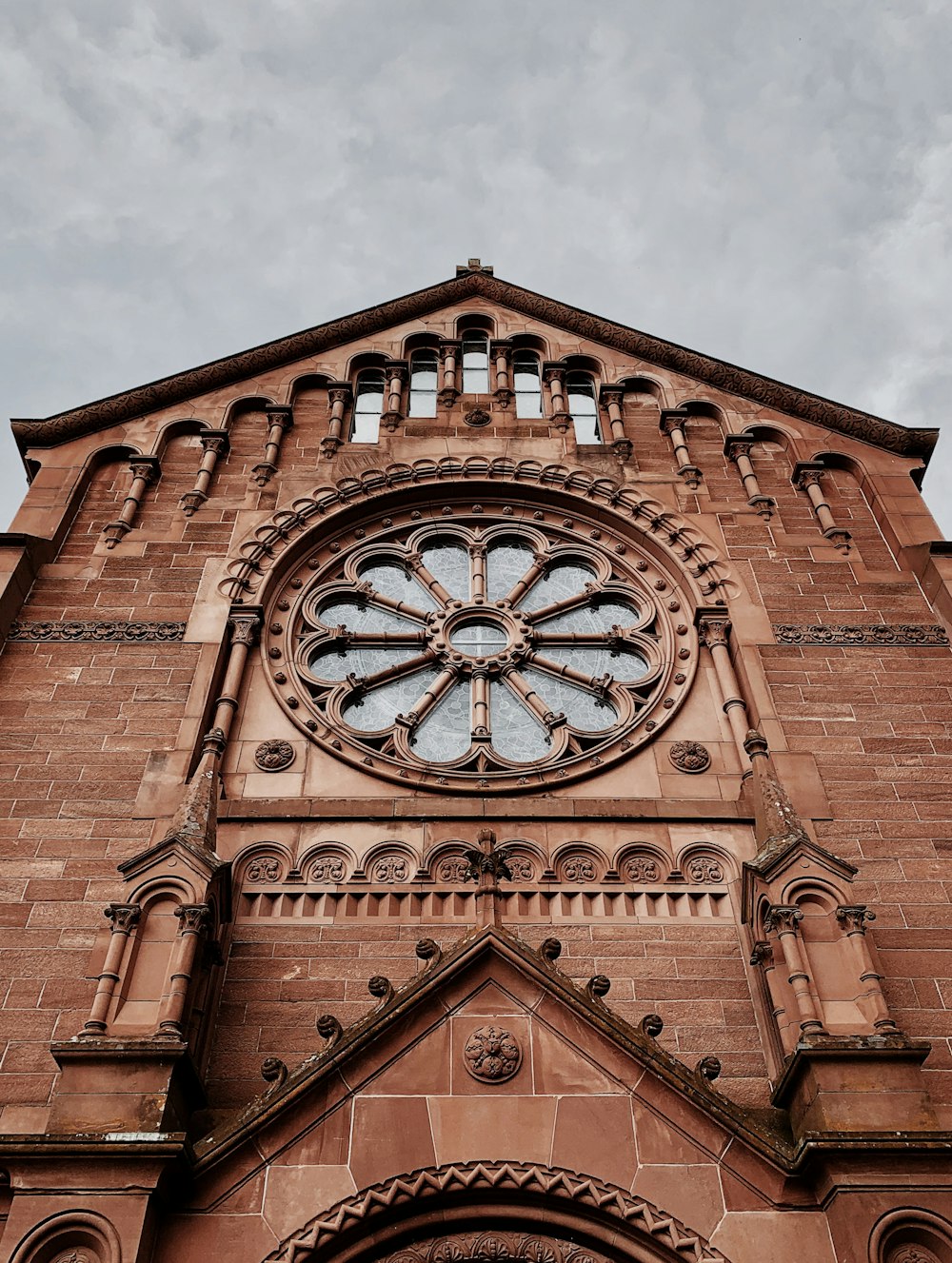 brown brick building under white clouds during daytime