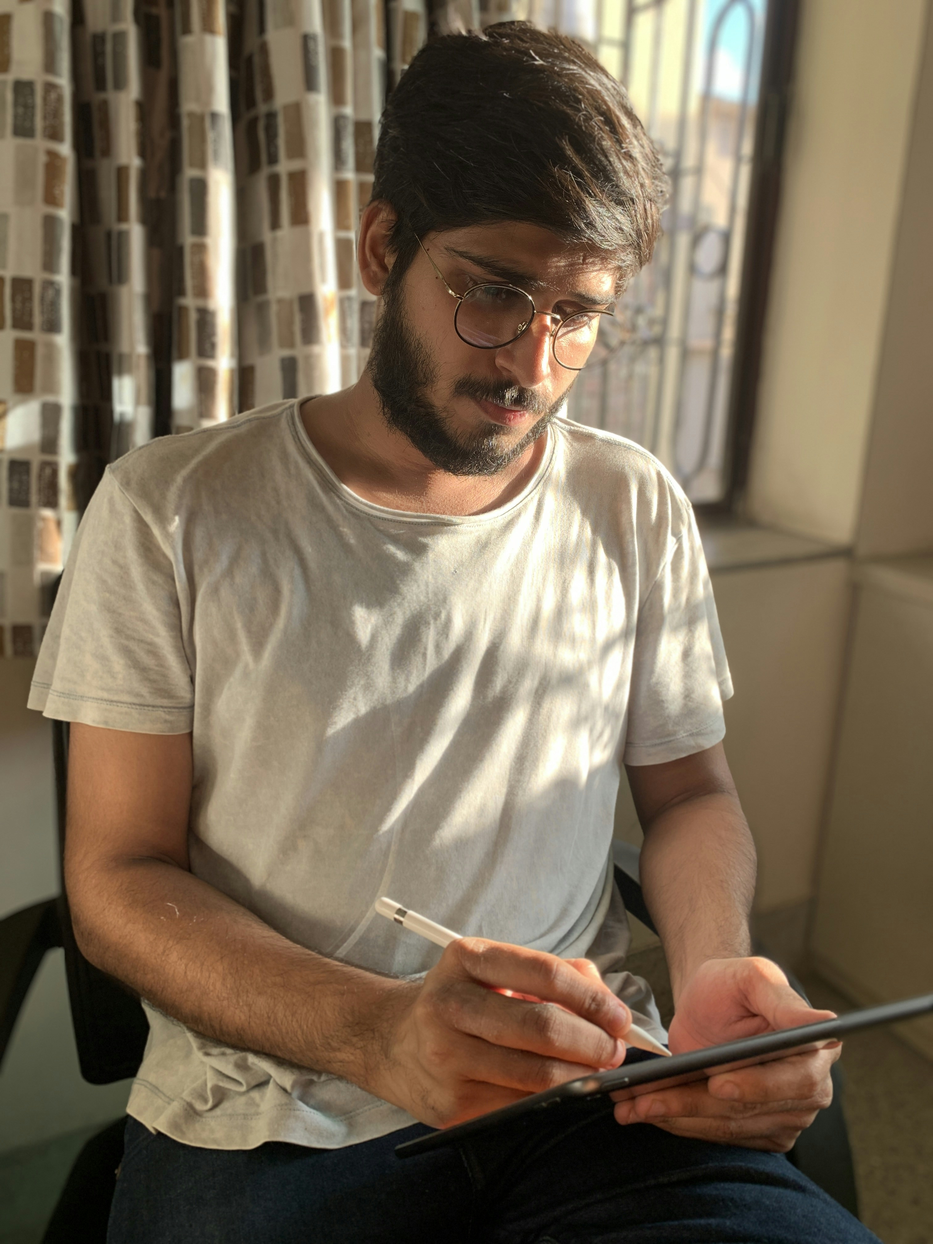 homem na camiseta branca do pescoço da tripulação segurando o smartphone