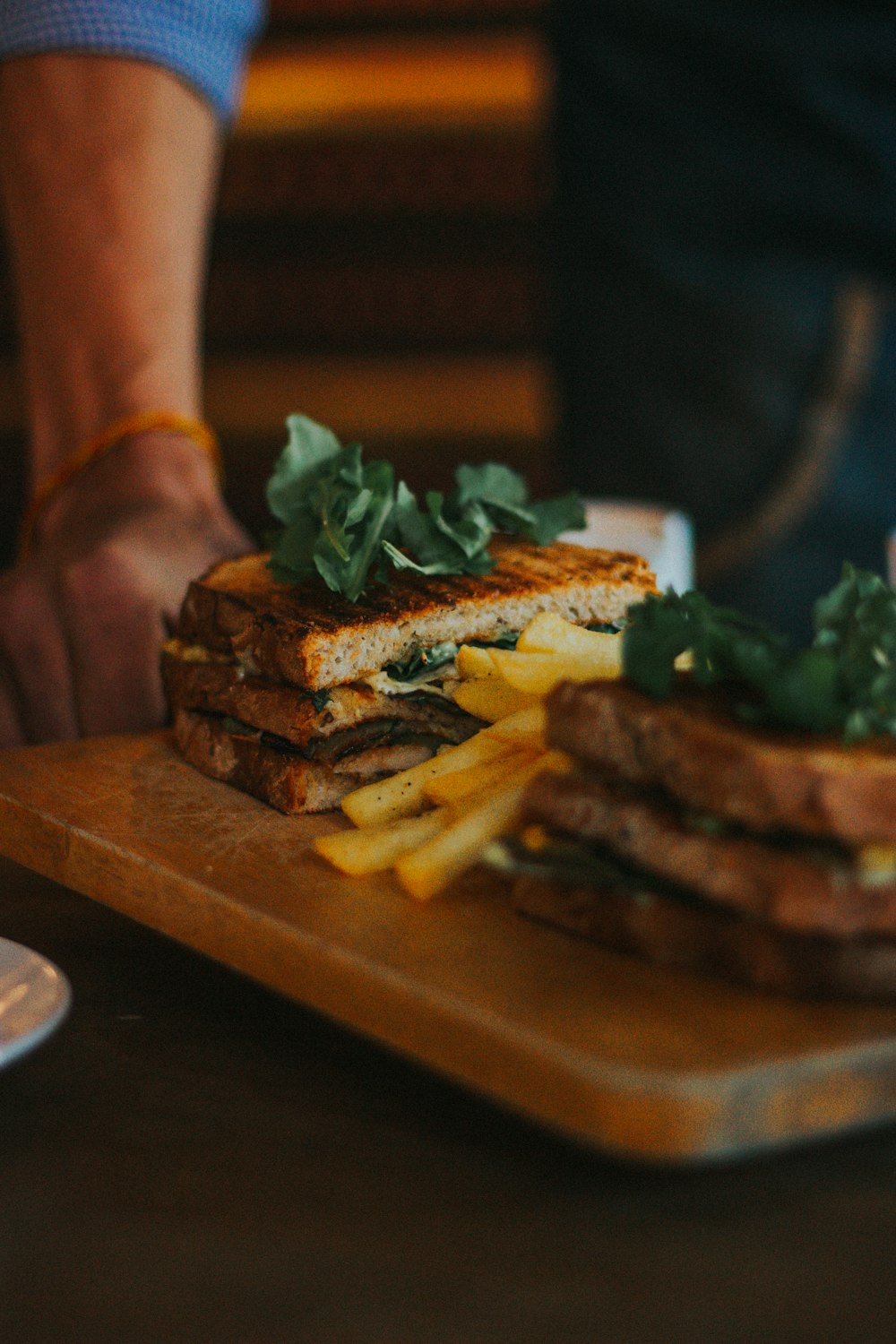 burger with fries on brown wooden tray