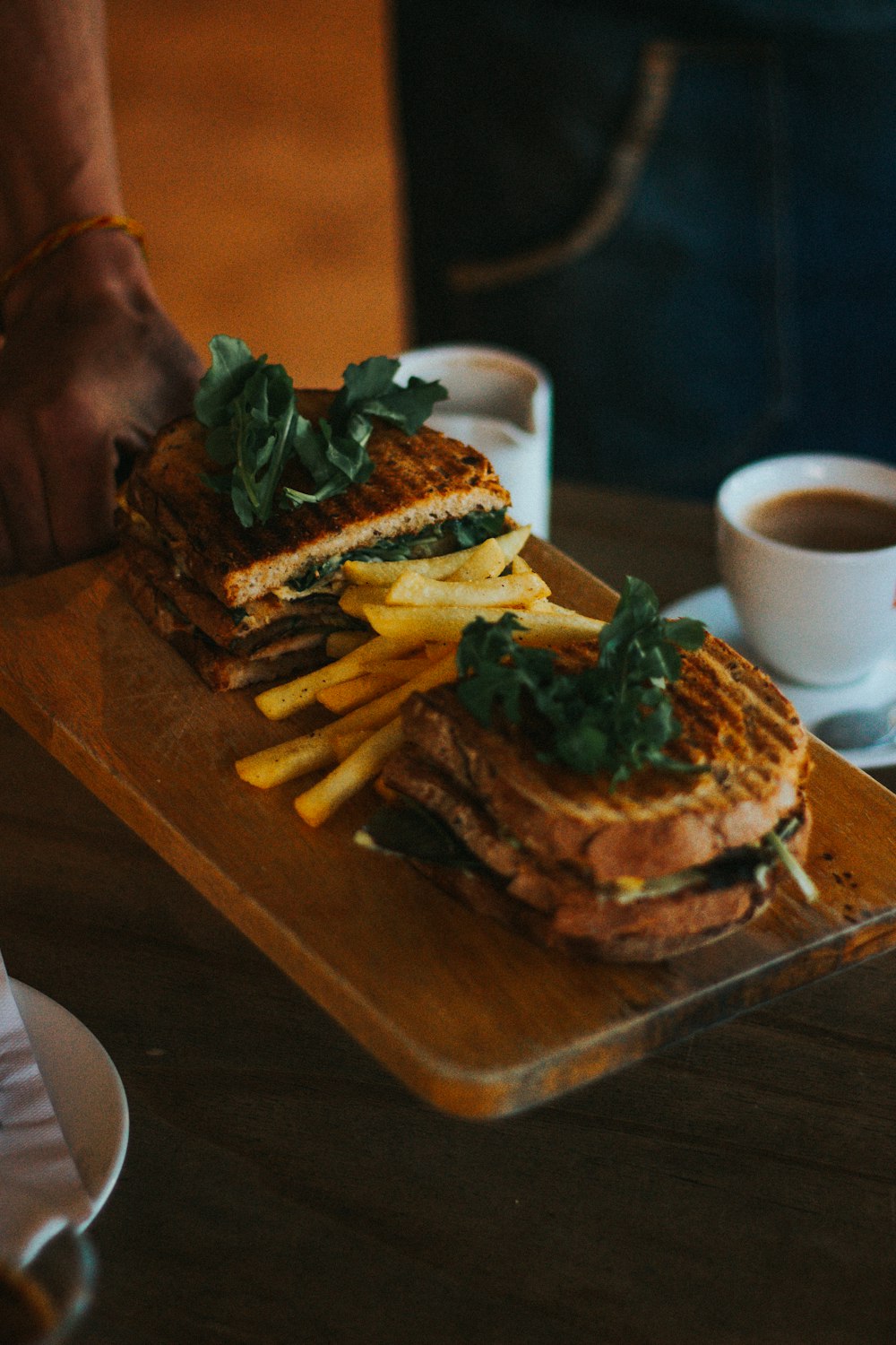 brown bread with green vegetable on brown wooden tray