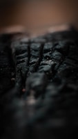 Close-up of a textured surface featuring deep black shades and subtle lighting.