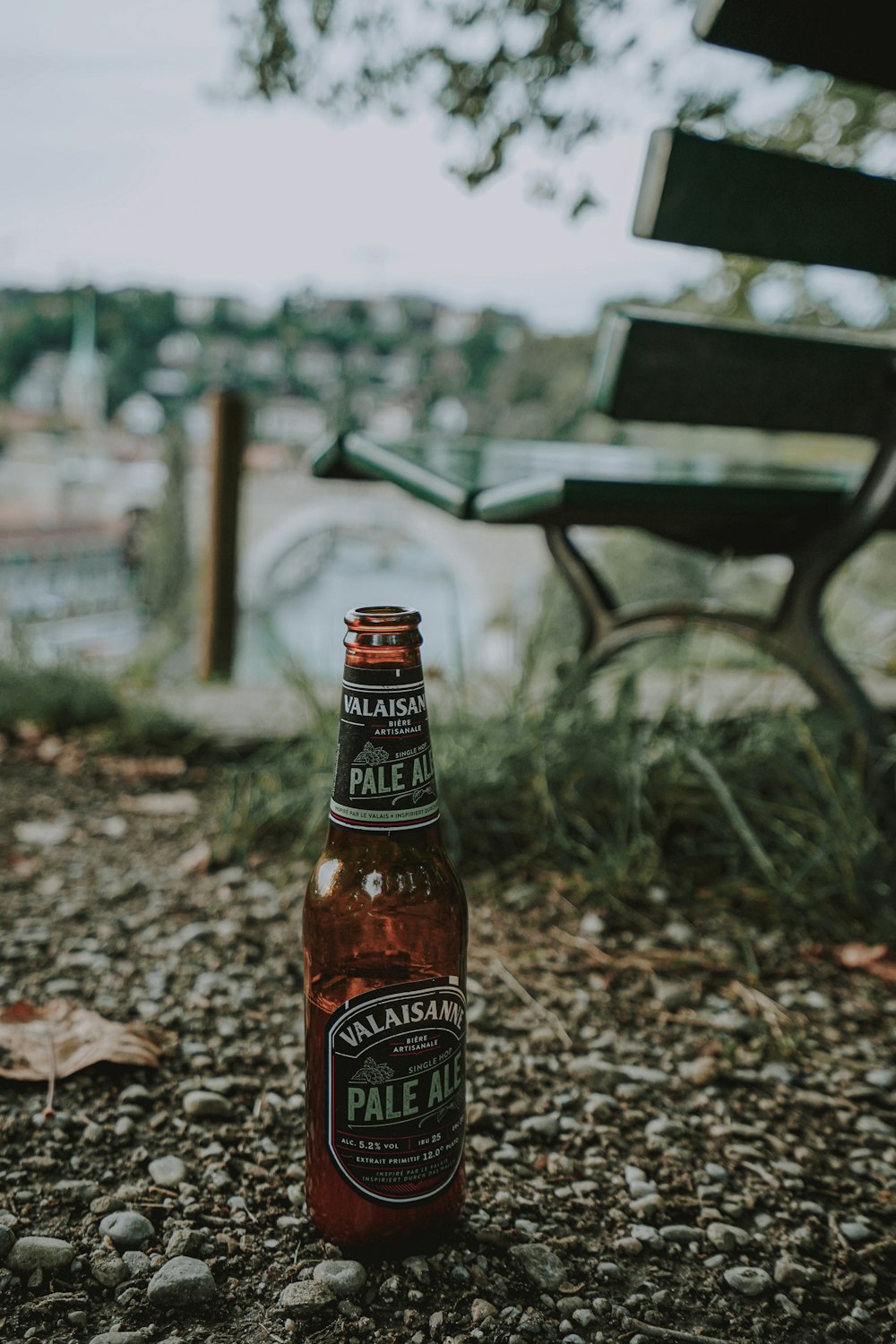 brown and white labeled bottle on ground