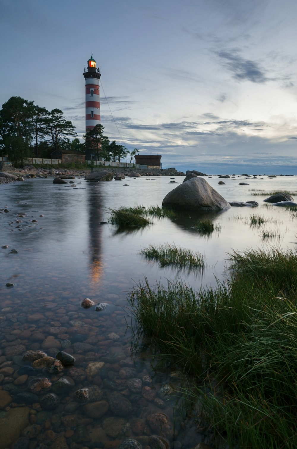 white and red lighthouse near body of water during daytime