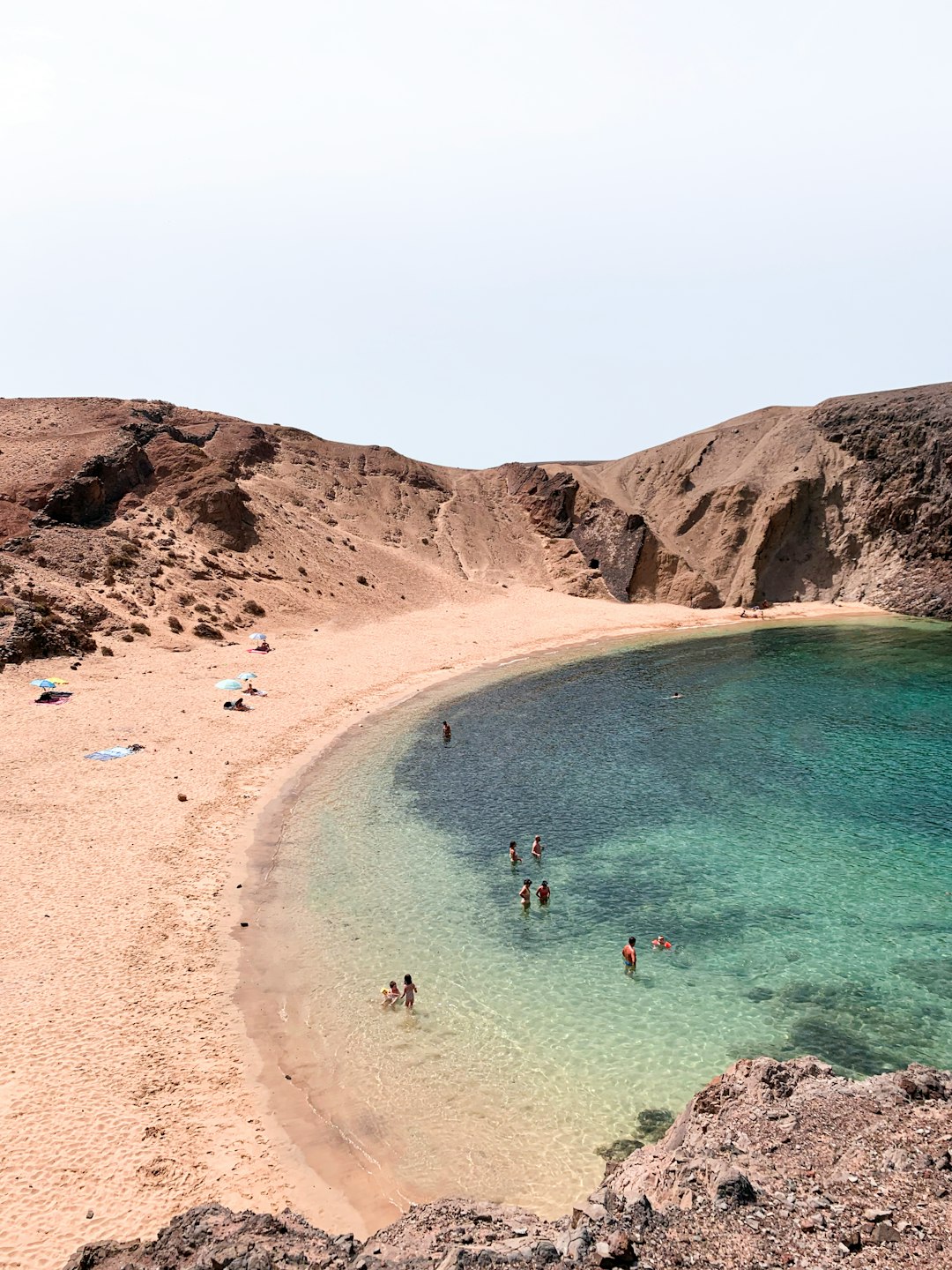 people swimming on beach during daytime